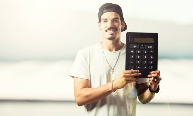 Tam hesaplamalar, veri bilgilerini yapıyor bir hesap makinesi tutan genç rapçi adam neşeli ve gülümseyerek,