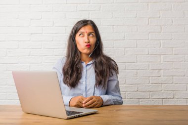 Genç Hintli kadın düşünce, fikir ve giyim kulaklık.