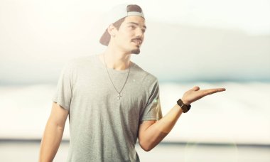 Elleriyle bir şey tutan, bir ürün, gülümseyen ve neşeli gösterilen, hayali bir nesne sunan genç rapçi adam