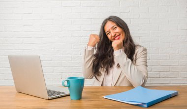Silah, bir zafer ya da başarı, piyango kazanan kutluyor yükselterek Genç Kızılderili kadın ofiste çok mutlu ve heyecanlı,