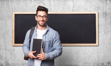 gri arka plan üzerine bir kitap tutan öğrenci adam
