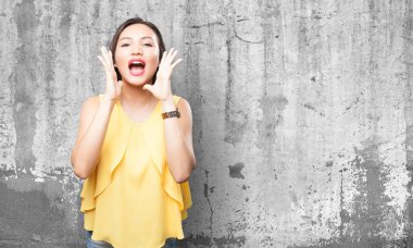 Asyalı kadın gri arka plan üzerine bağırarak
