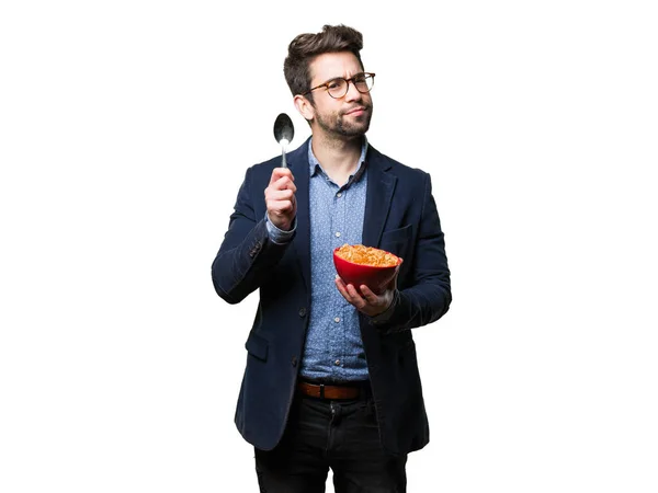 Mladý Muž Myslí Drží Miskou Corn Flakes Izolovaných Bílém Pozadí — Stock fotografie