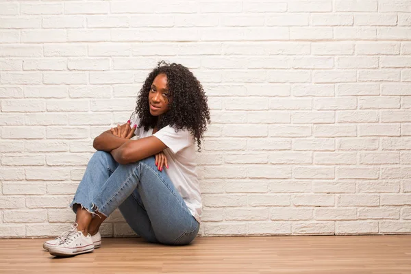 Jovem Mulher Negra Sentada Chão Madeira Com Braços Cruzados Contra — Fotografia de Stock