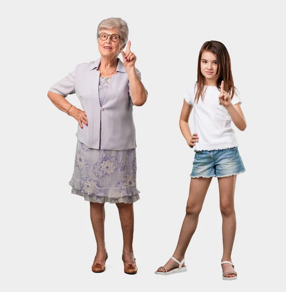 年配のご婦人とナンバーワン カウントのシンボル 自信を持って明るく 数学の概念を示す彼女の孫娘の全身 — ストック写真