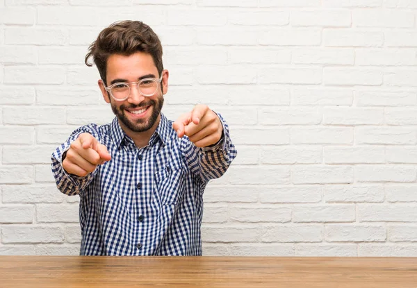 Jovem Caucasiano Sentado Alegre Sorrindo Apontando Para Frente — Fotografia de Stock