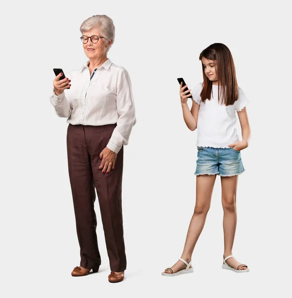 高齢者女性のインターネットやソーシャル ネットワーク 未来の肯定的な感情と現代を使用して 携帯電話に触れる彼女の孫娘幸せでリラックスして — ストック写真