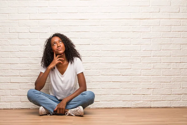 Νεαρή Μαύρη Γυναίκα Που Κάθεται Ένα Ξύλινο Πάτωμα Αμφιβολία Και — Φωτογραφία Αρχείου