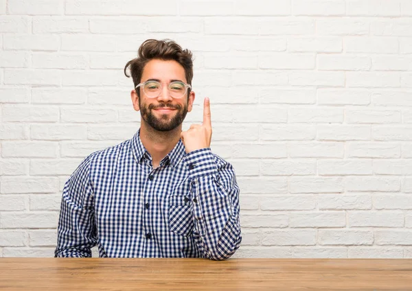 Unga Kaukasiska Man Sittande Visar Nummer Ett Symbol För Inventering — Stockfoto