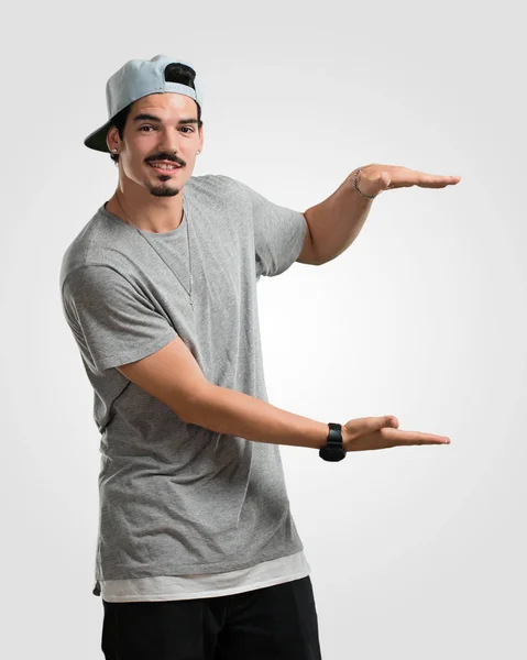 Young Rapper Man Holding Something Hands Showing Product Smiling Cheerful — Stock Photo, Image