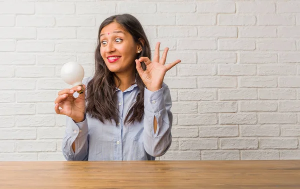 Young indian woman cheerful and confident doing ok gesture, excited and screaming, concept of approval and success