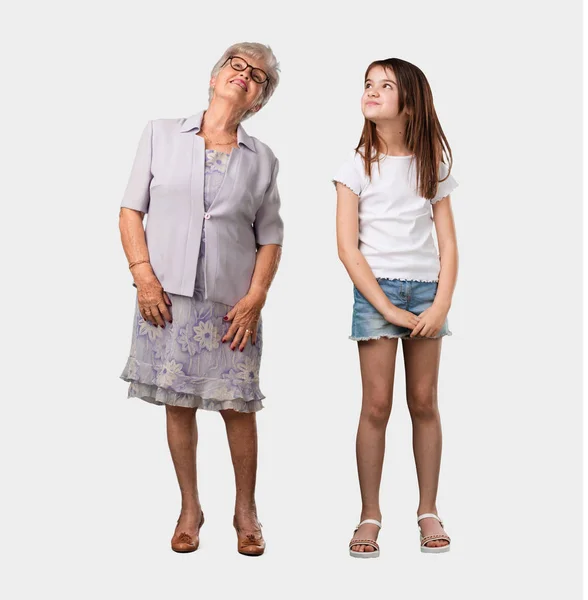 整个身体的老太太和她的孙女仰望 思考的东西有趣和有一个想法 想象力的概念 快乐和兴奋 — 图库照片