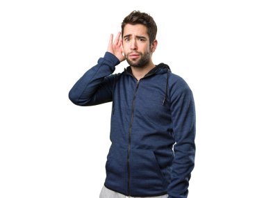 Genç adam izole üzerinde beyaz arka plan dinleme