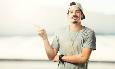 Sürpriz bir şey, doğal ve rahat sunan gülümseyen tarafına işaret eden genç rapçi adam