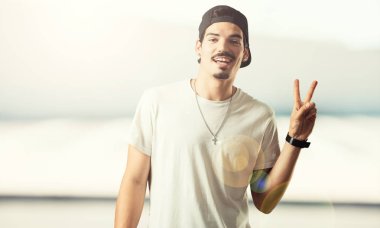 Genç rapçi adam eğlenceli ve mutlu, pozitif ve doğal, zafer, barış kavramı bir jest yapar