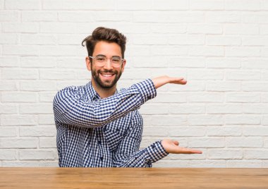 Genç beyaz adam eliyle bir şey tutan