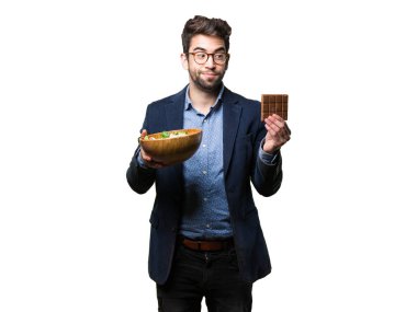 Genç adam arasında çikolata ve beyaz arka plan üzerinde izole salata seçimi