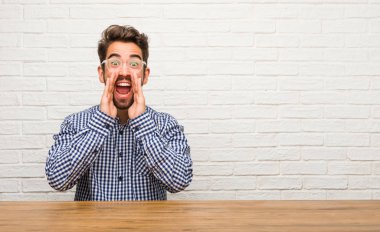 Beyaz delikanlı oturma bir teklif ya da bir promosyon tarafından şaşırttı mutlu, çığlık, atlama ve gurur ağzı açık