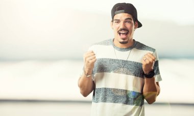 Silah, bir zafer ya da başarı, piyango kazanan kutluyor yükselterek genç rapçi adam çok mutlu ve heyecanlı,