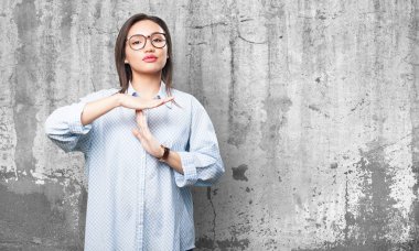 Asyalı kadın grunge gri arka plan üzerinde mola jest yapıyor