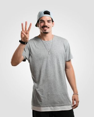 Gösterilen üç numaralı sayma simgesi, matematik, kendinden emin ve neşeli kavramı genç rapçi adam