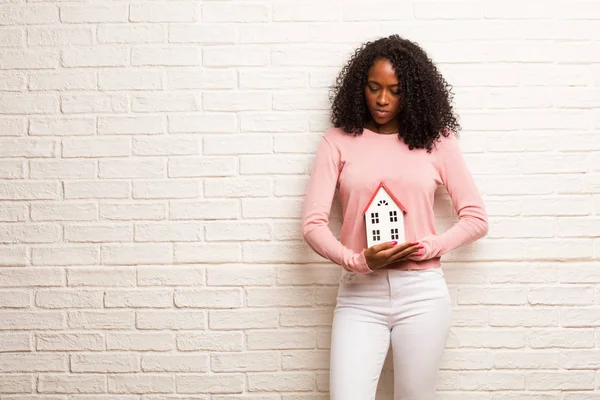 小黑人妇女与模型房子心烦和反对砖墙 — 图库照片