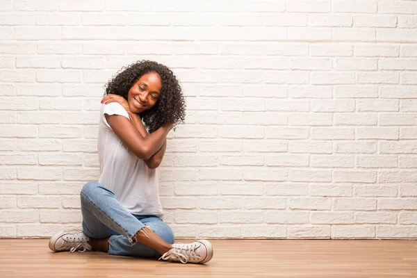 Young Black Woman Sitting Wooden Floor Hugging Herself Brick Wall — Stock Photo, Image