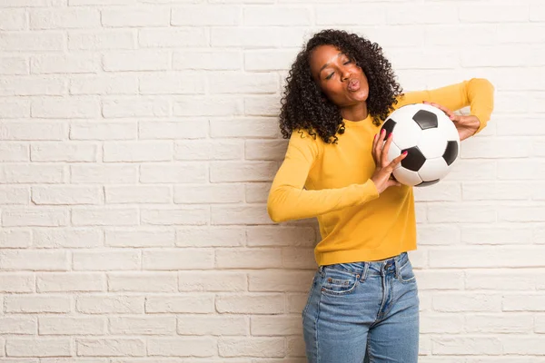 Jonge Zwarte Vrouw Met Voetbal Maken Kussen Expressie Tegen Muur — Stockfoto