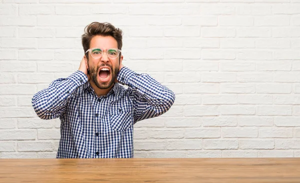 Junger Kaukasischer Mann Sitzt Verrückt Und Verzweifelt Schreit Außer Kontrolle — Stockfoto