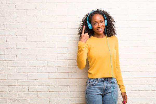 Young Black Woman Headphones Showing Number One Brick Wall — Stock Photo, Image