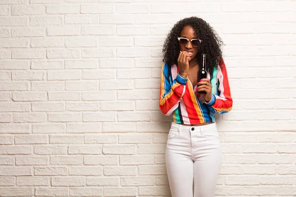 Young Black Woman Colorful Shirt Beer Bottle Biting Nails Brick — Stock Photo, Image