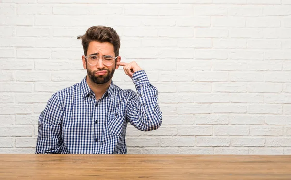 Joven Hombre Caucásico Sentado Cubriendo Los Oídos Con Las Manos — Foto de Stock