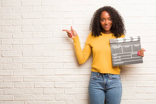 Joven Mujer Negra Con Clapboard Apuntando Hacia Lado Sonriendo Contra —  Fotos de Stock