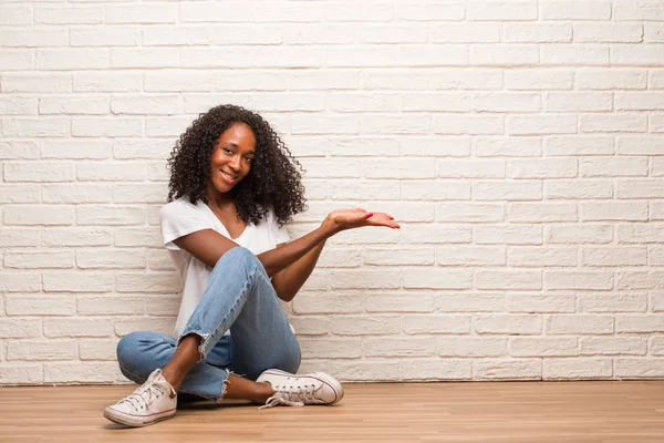 Ung Svart Kvinna Som Sitter Ett Trägolv Som Håller Imaginära — Stockfoto