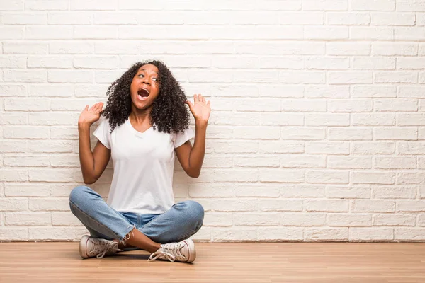 Young Black Woman Sitting Wooden Floor Screaming Happy Brick Wall — Stock Photo, Image