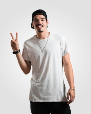 Genç rapçi adam eğlenceli ve mutlu, pozitif ve doğal, zafer, barış kavramı bir jest yapar