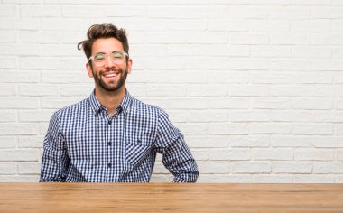 Beyaz delikanlı ile otururken, ayakta rahat ve gülümseyen, çok olumlu ve neşeli kalçalarına eller