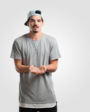 Elleriyle bir şey tutan, bir ürün, gülümseyen ve neşeli gösterilen, hayali bir nesne sunan genç rapçi adam