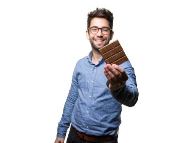 Beyaz arka plan üzerinde izole bir çikolata tutan genç adam
