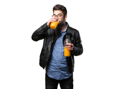 Genç adam beyaz arka plan üzerinde izole bir portakal suyu içme