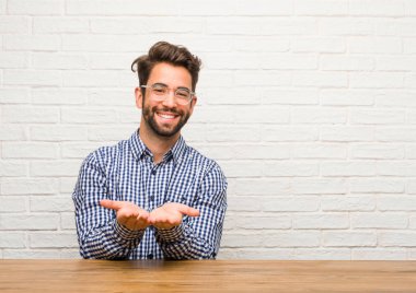 Genç beyaz adam eliyle bir şey tutan