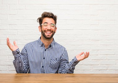 Kendinden emin ve başarılı rahat ve neşeli, gülen ve having fun, oturan genç beyaz adam geliyor