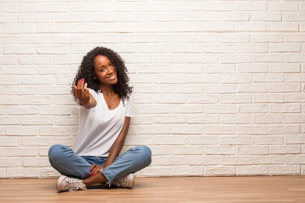 Joven Mujer Negra Sentada Suelo Madera Invitando Venir Contra Pared —  Fotos de Stock