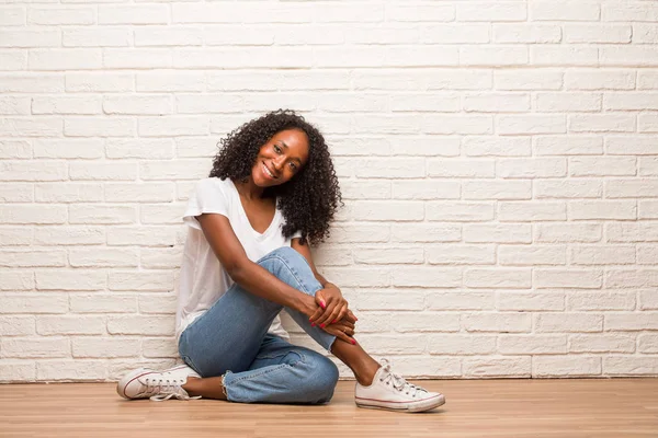 Joven Mujer Negra Sentada Suelo Madera Con Una Sonrisa Relajada — Foto de Stock