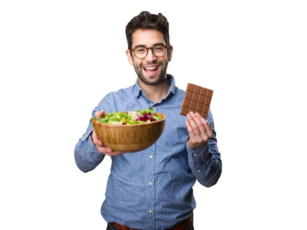 Joven Sosteniendo Una Ensalada Una Barra Chocolate Aislada Sobre Fondo — Foto de Stock