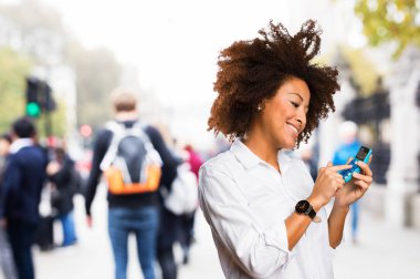 bir hesap makinesi üzerinde arka plan bulanık kullanan genç siyah kadın