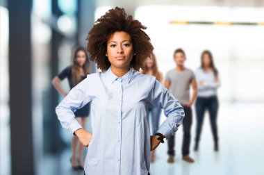 arka plan bulanık insanlarla duran genç siyah kadın