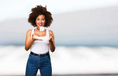 Genç siyah kadın bir zar ile oynarken arka plan bulanık