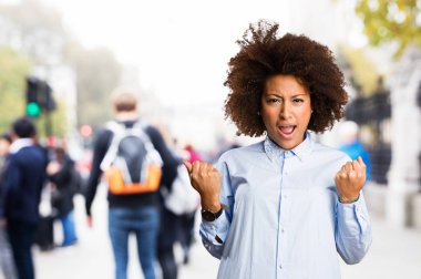 Genç siyah kadının arka plan bulanık kazanan jest yapması