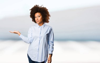 bir şey üzerinde arka plan bulanık tutan genç siyah kadın